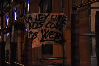 Cartel colgado de un andamio.