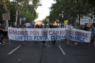 Varios manifestantes que sostienen un cartel.