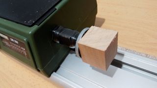 Cubo de madera sujeto en el torno.